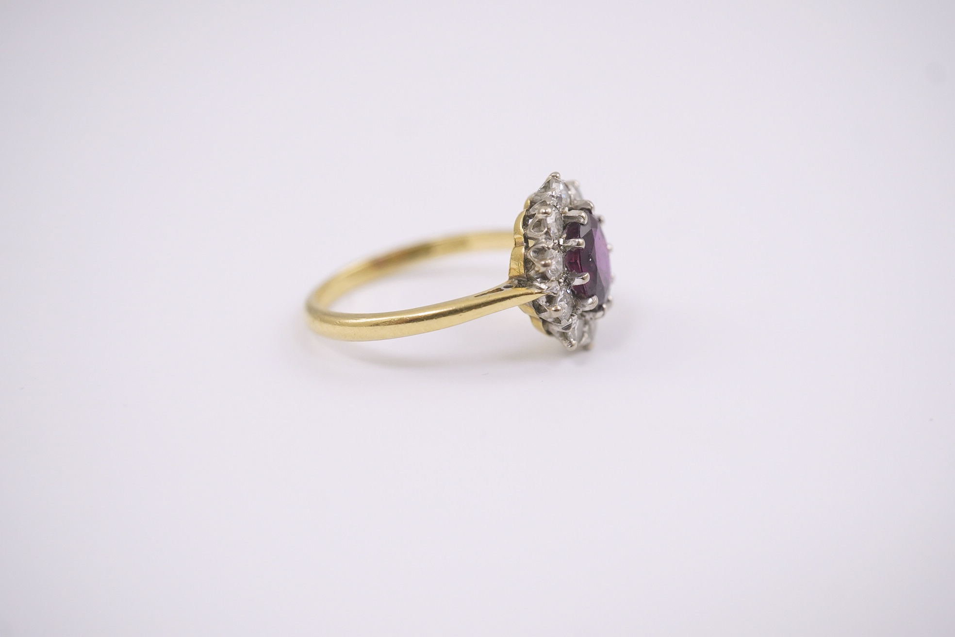 An 18ct gold and platinum, ruby and diamond set oval cluster ring